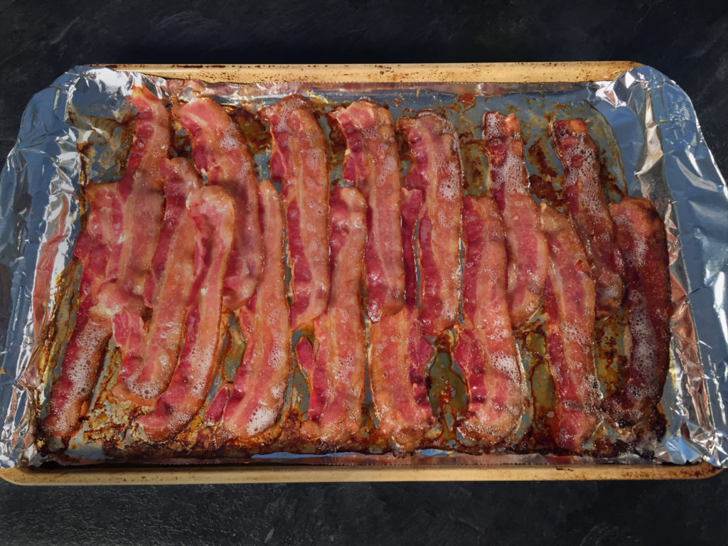 cooked bacon on a cookie sheet