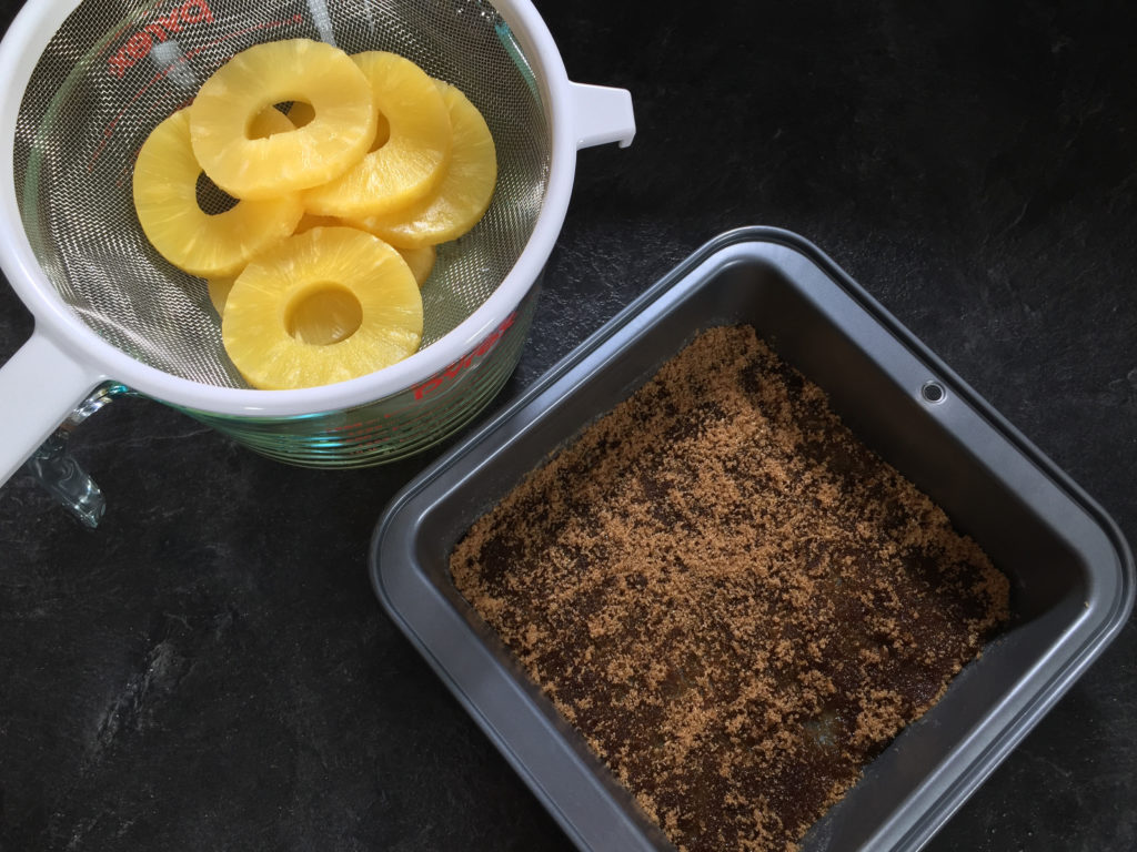 Draining the pineapple to go in the cake pan