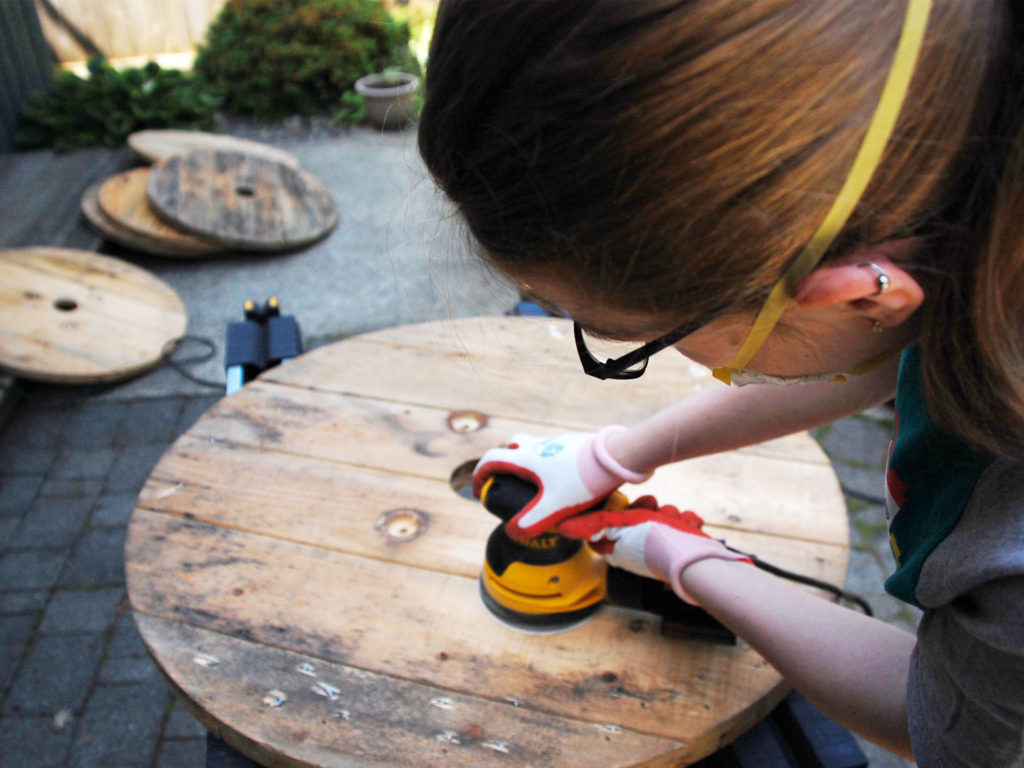 sanding wooden cable spool