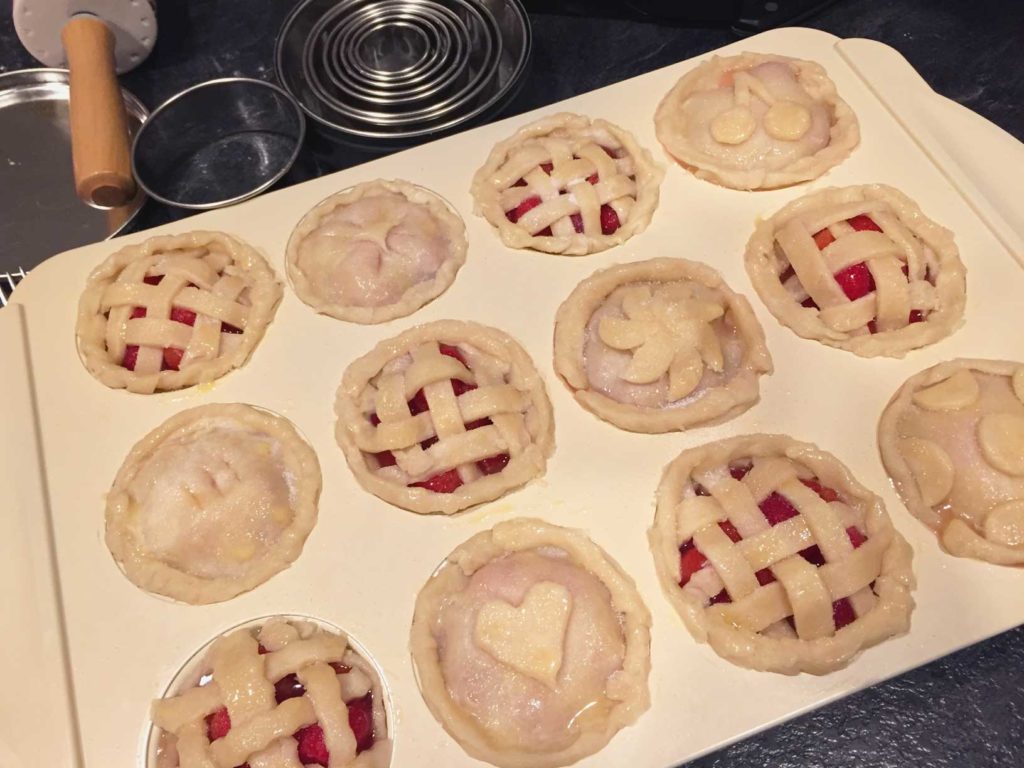 Overhead view of the mini pies, decorated with dough, ready to go in the oven