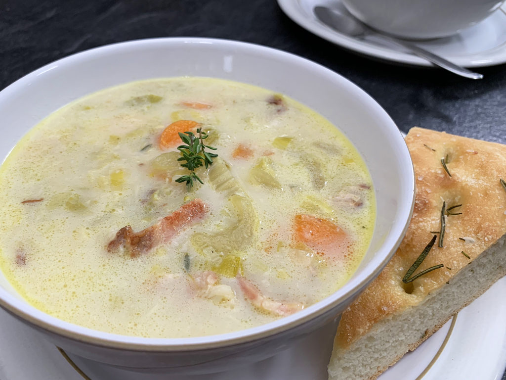 bowl of creamy potato bacon leek soup with focaccia bread