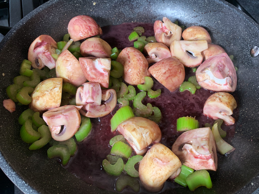 mushrooms and celery in frying pan with wine