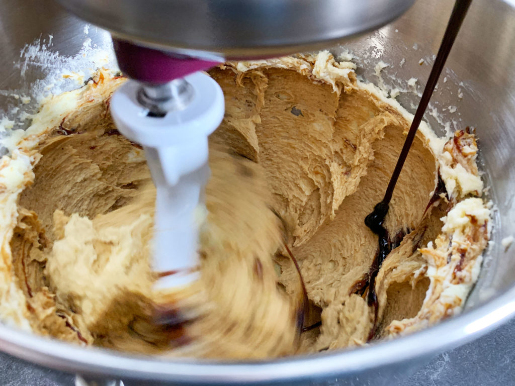 pouring molasses into bowl of butter and sugar