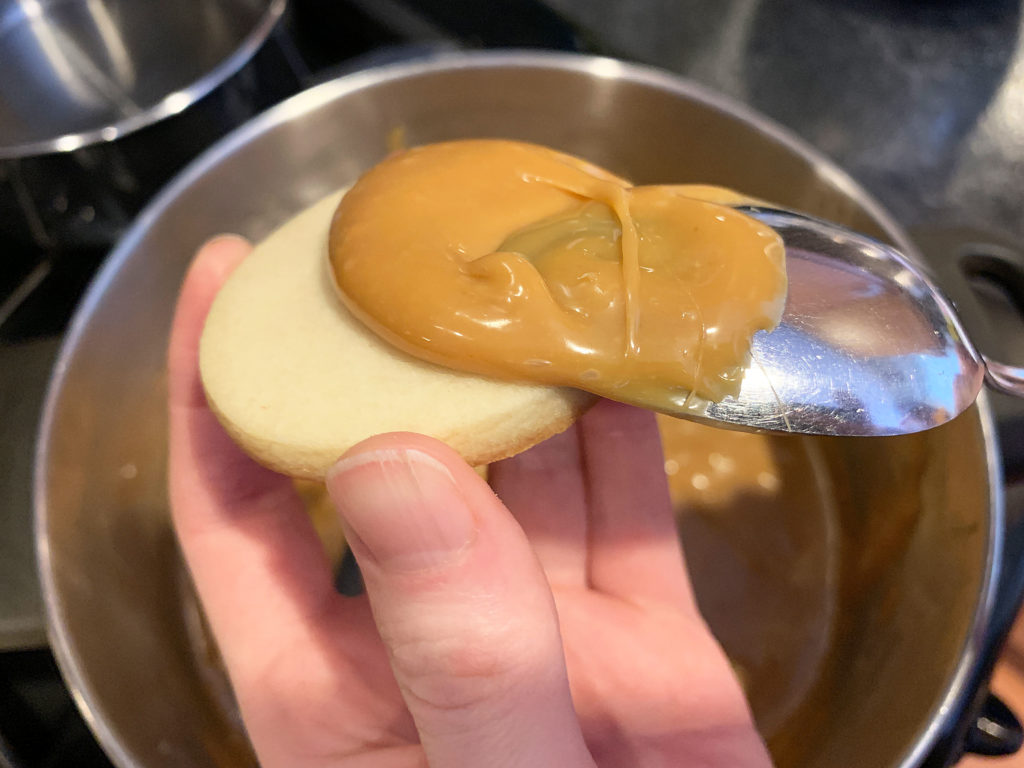 scooping caramel onto the cookie