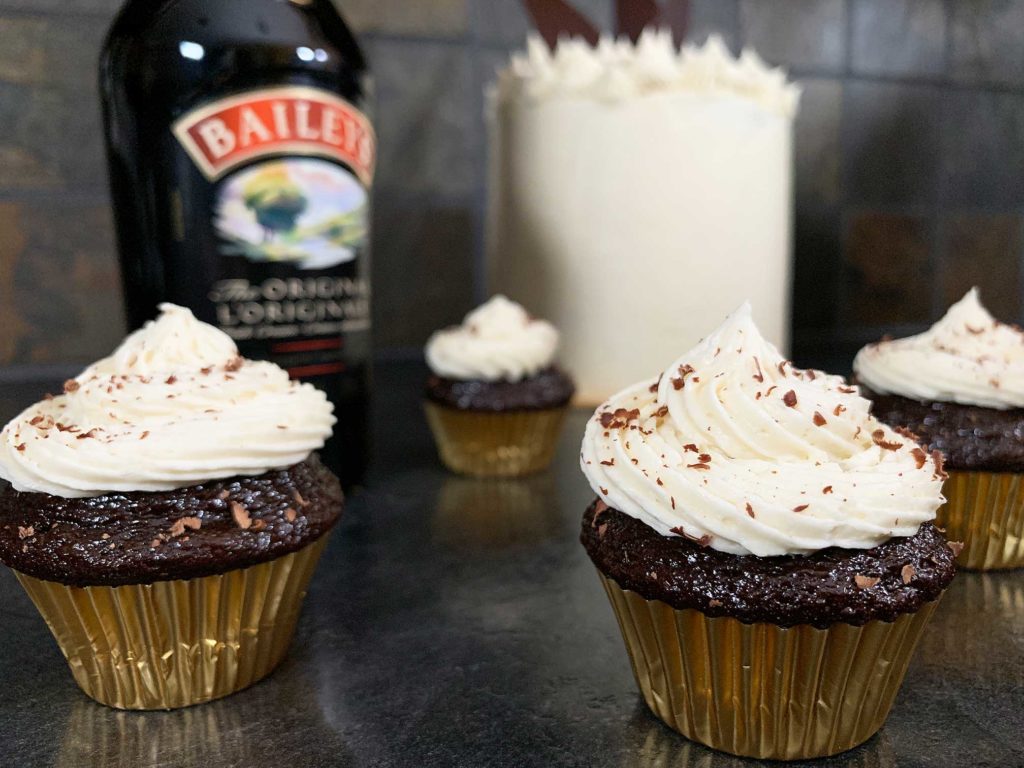 close up of chocolate cupcakes with cake in the background