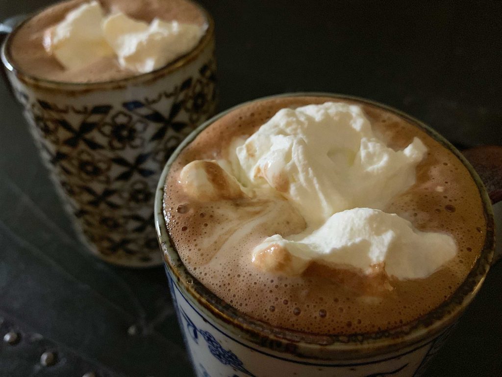 hot chocolate in mugs, topped with whipped cream