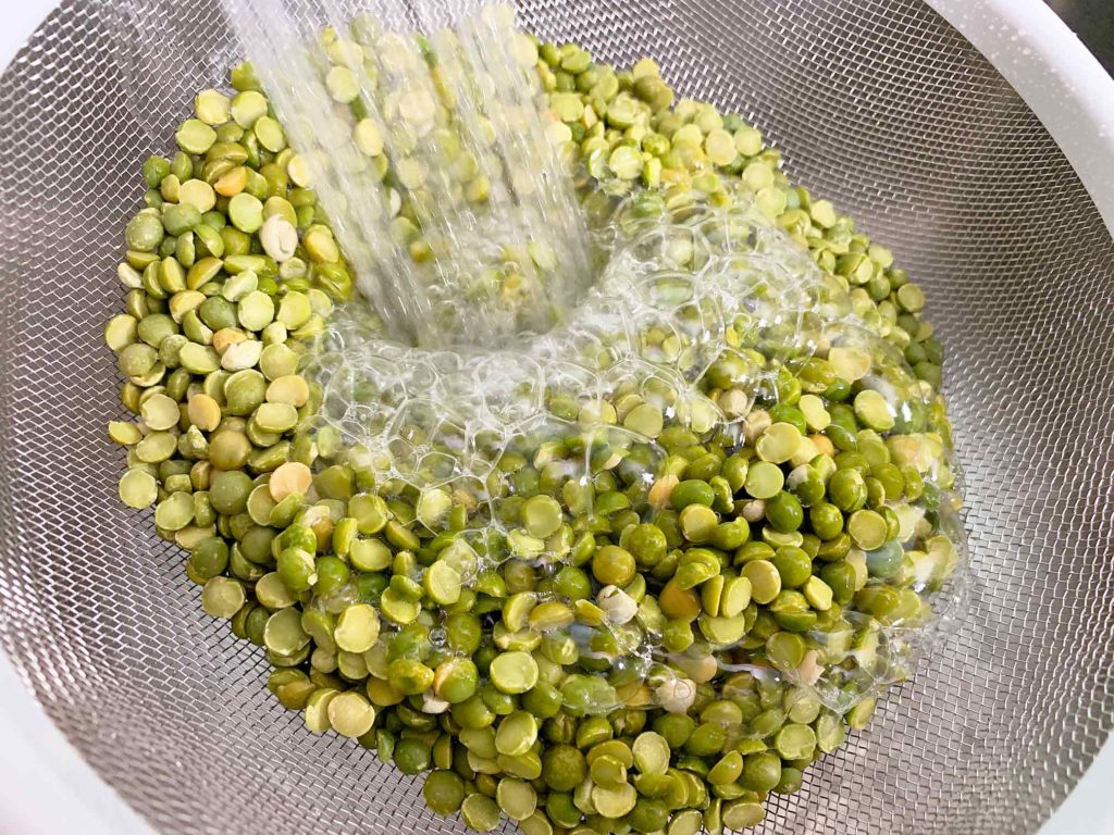 rinsing the dried split peas in a strainer