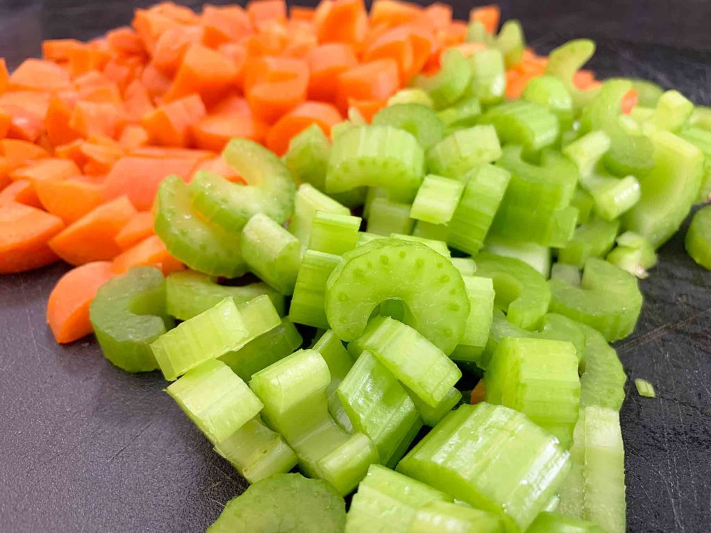 chopped up celery and carrot on a cutting board