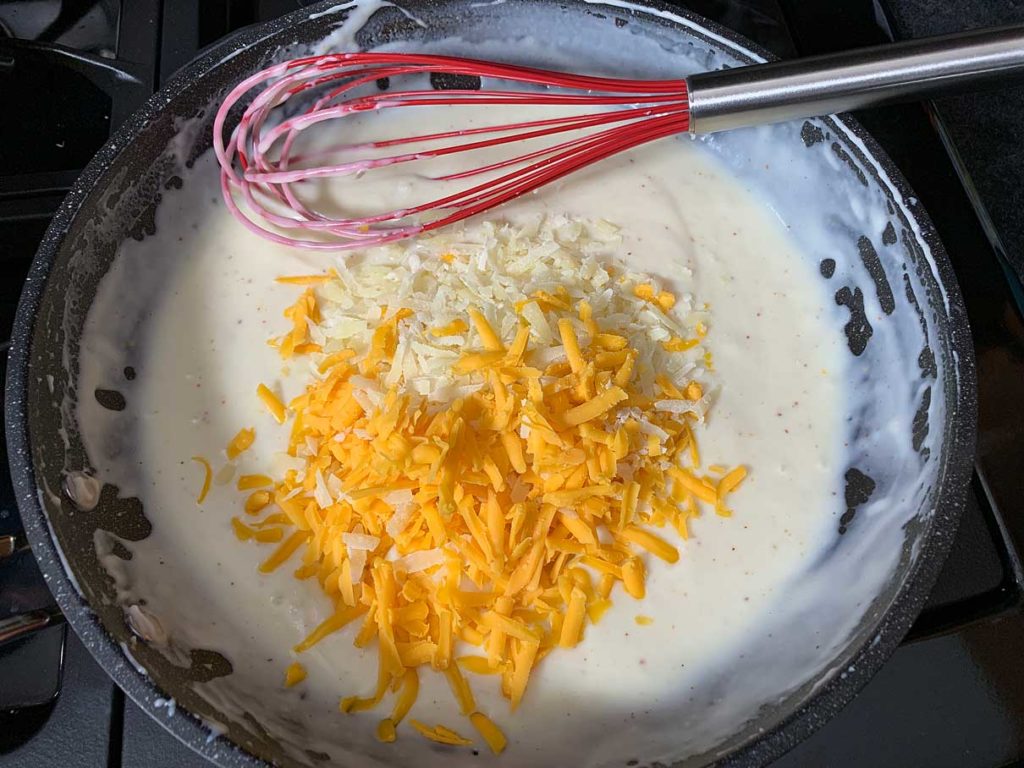 adding the cheese to the cream sauce