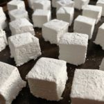 Close up shot of a pan full of homemade marshmallows, cut into cubes