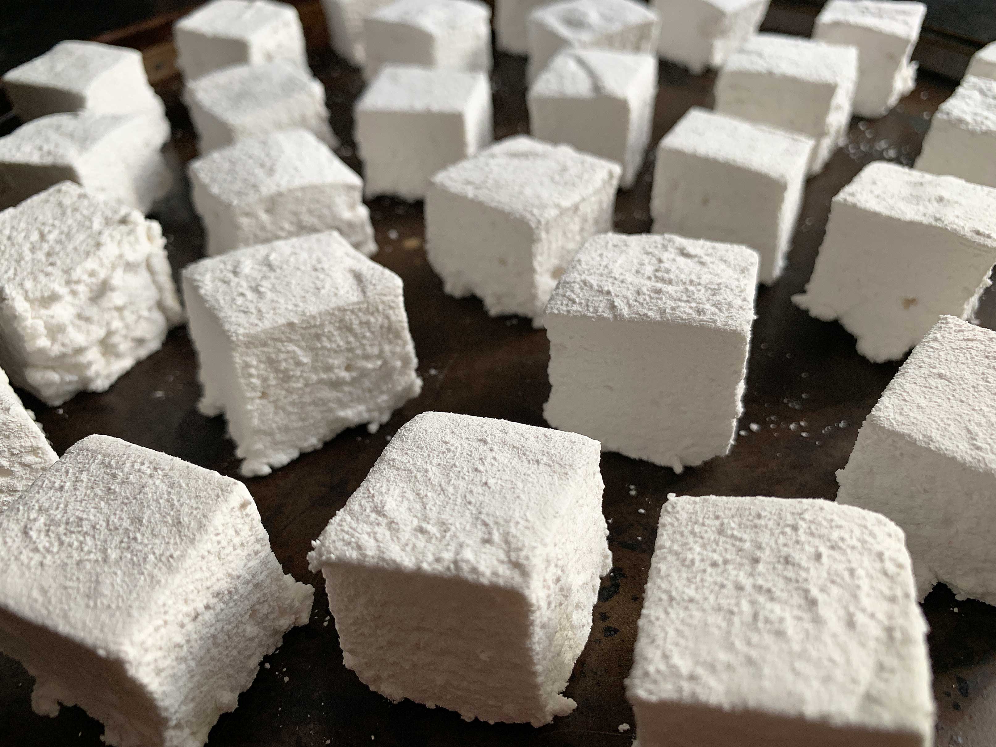 Close up shot of a pan full of homemade marshmallows, cut into cubes