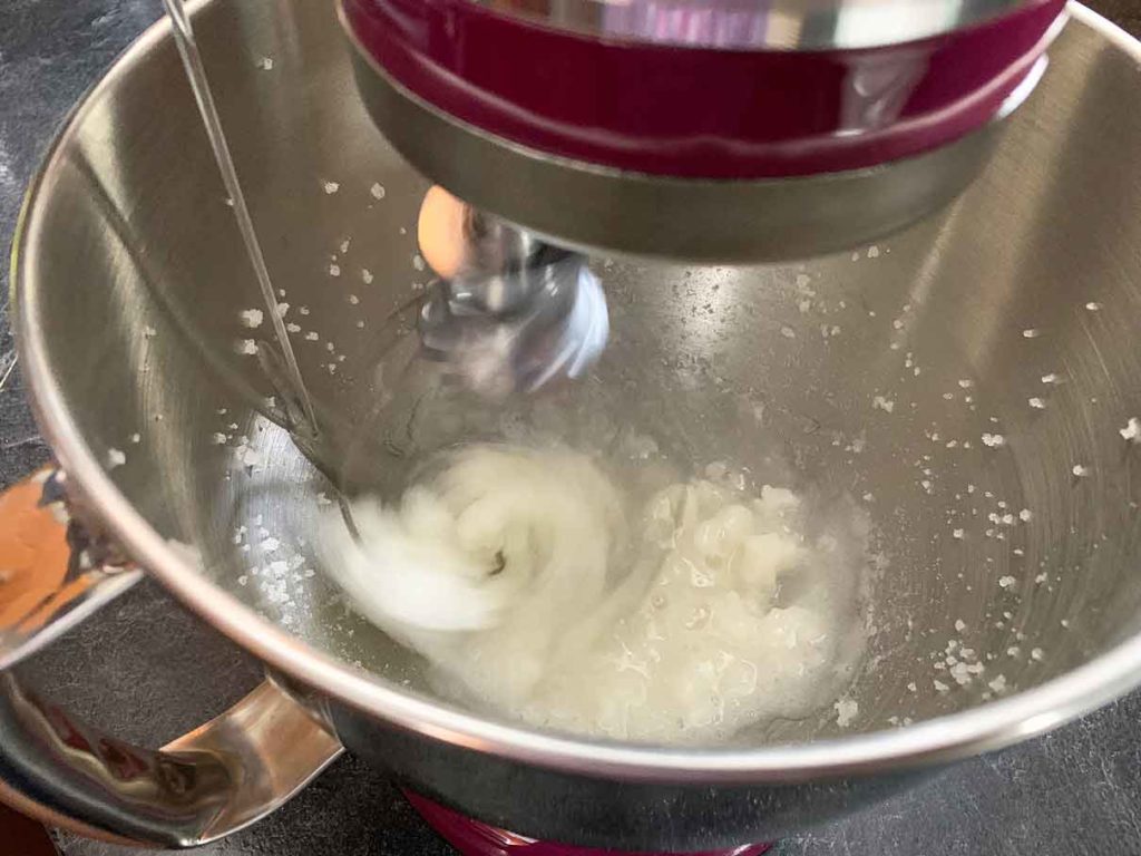 Pouring hot syrup into a mixing bowl with gelatin