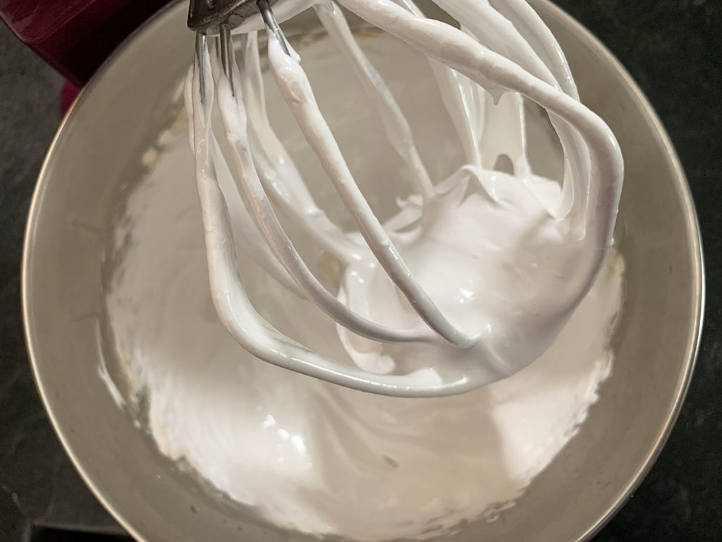 Whipped up marshmallow fluff in the bowl of a stand mixer