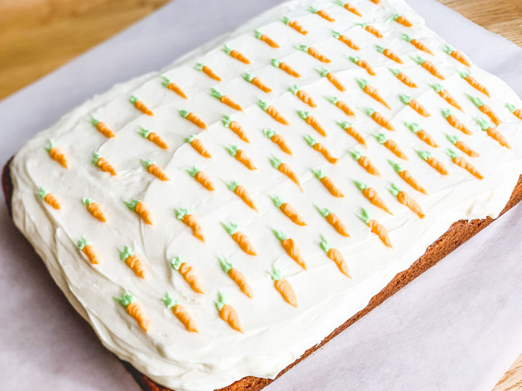 frosted carrot cake, with tiny carrots piped on top