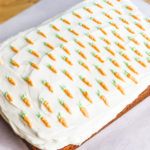 frosted carrot cake, with tiny carrots piped on top