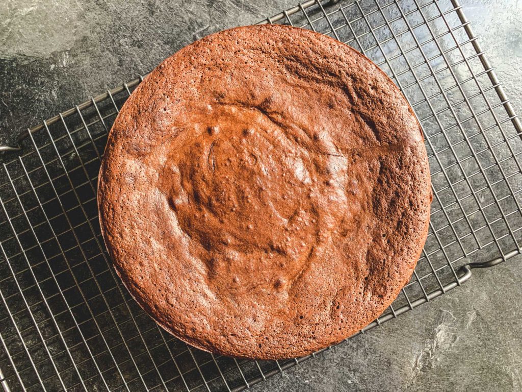 overhead shot of flourless chocolate cake on a cooling rack