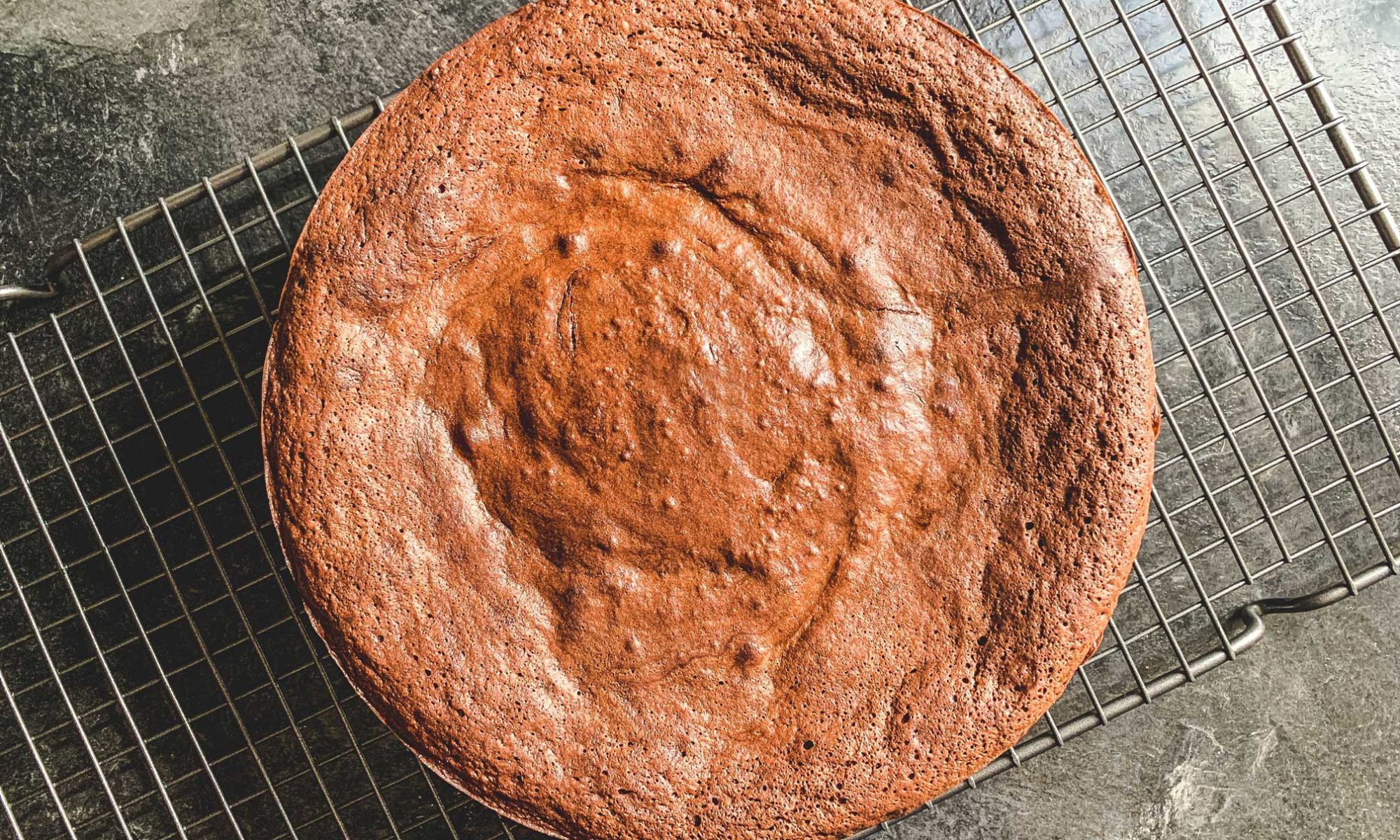 overhead shot of flourless chocolate cake on a cooling rack