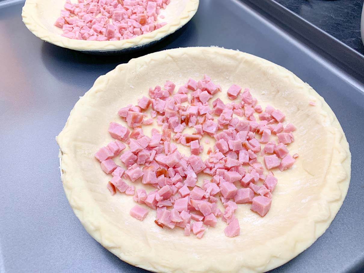 ham sprinkled onto bottom of pie shell
