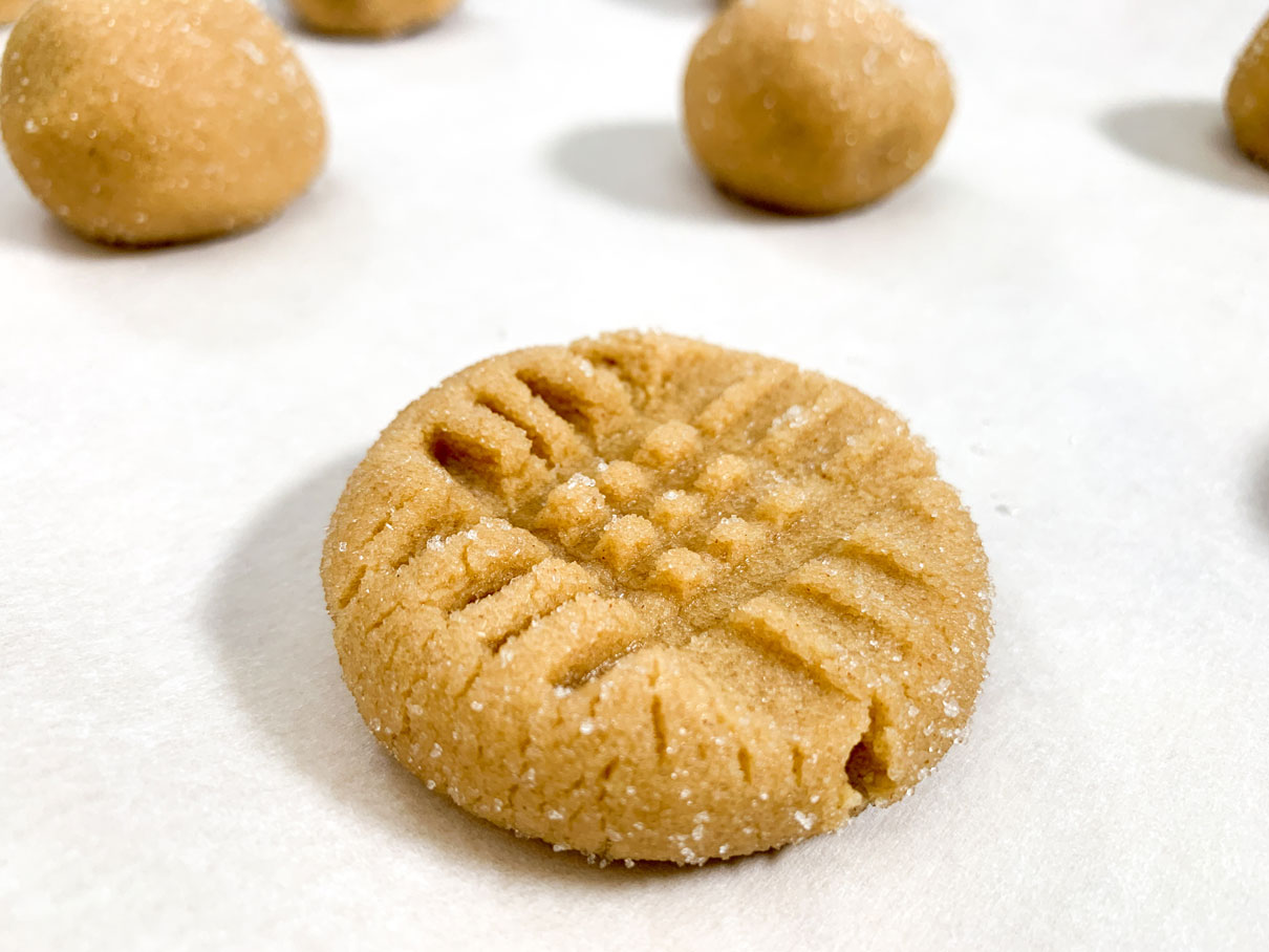 Peanut butter cookie dough ball with fork marks pressed into the surface