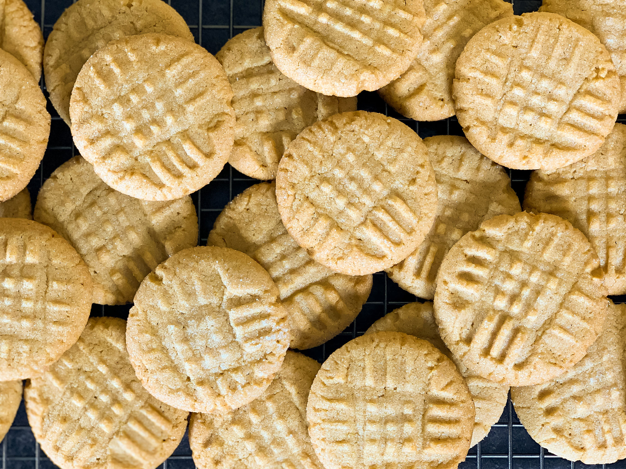 Peanut butter cookies stacked on a wire cooling rack
