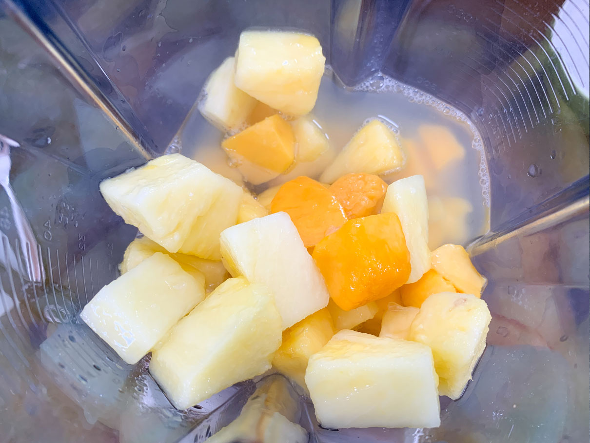 Frozen mango and pineapple in a blender with tequila and lime juice.