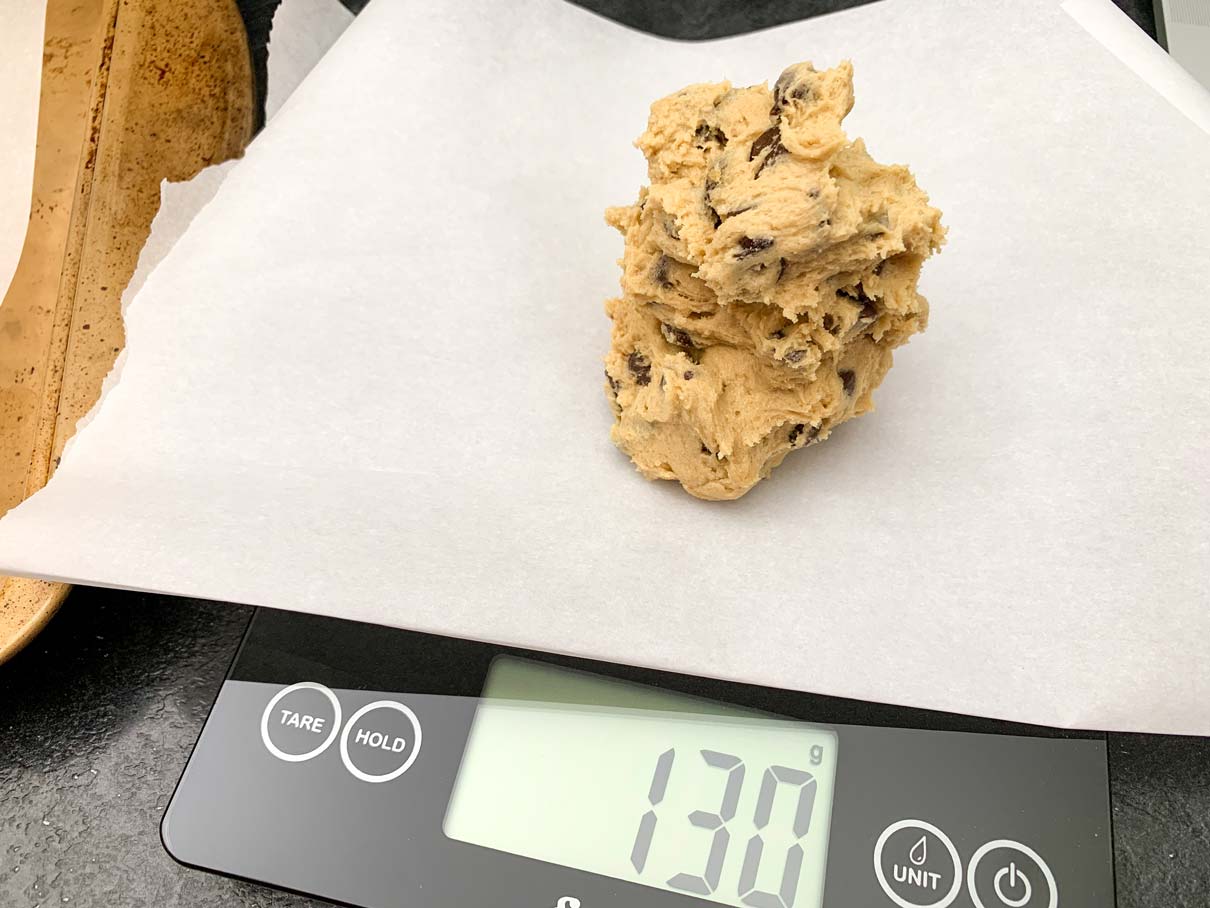 A ball of cookie dough being weighed on a scale