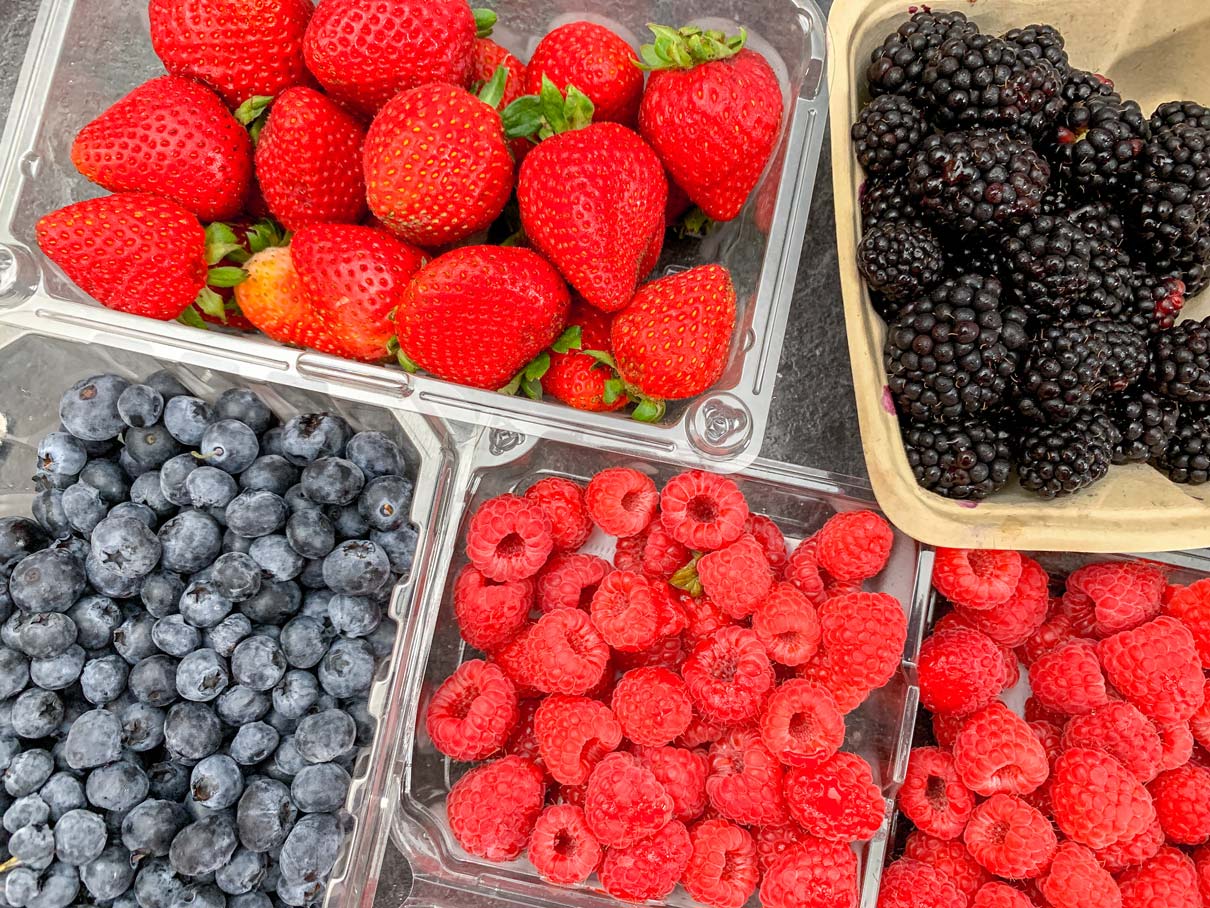 containers of strawberries, blackberries, blueberries and raspberries on the counter