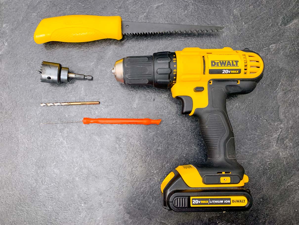 dry wall saw, hole saw bit, drill bit, pumpkin carving knife and drill sitting on the counter top