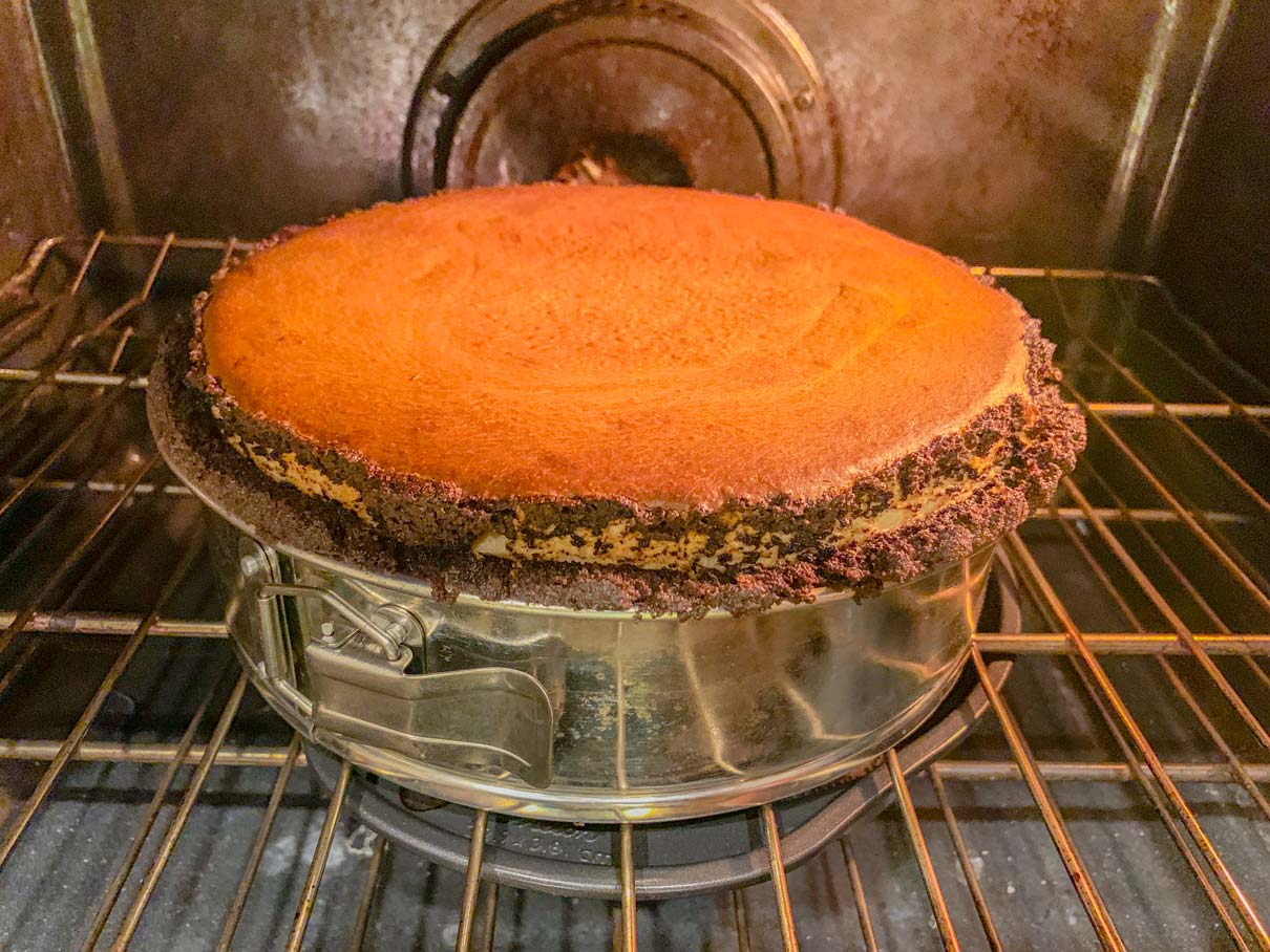 The cheesecake, still in the oven and looking very puffed and slightly overbaked