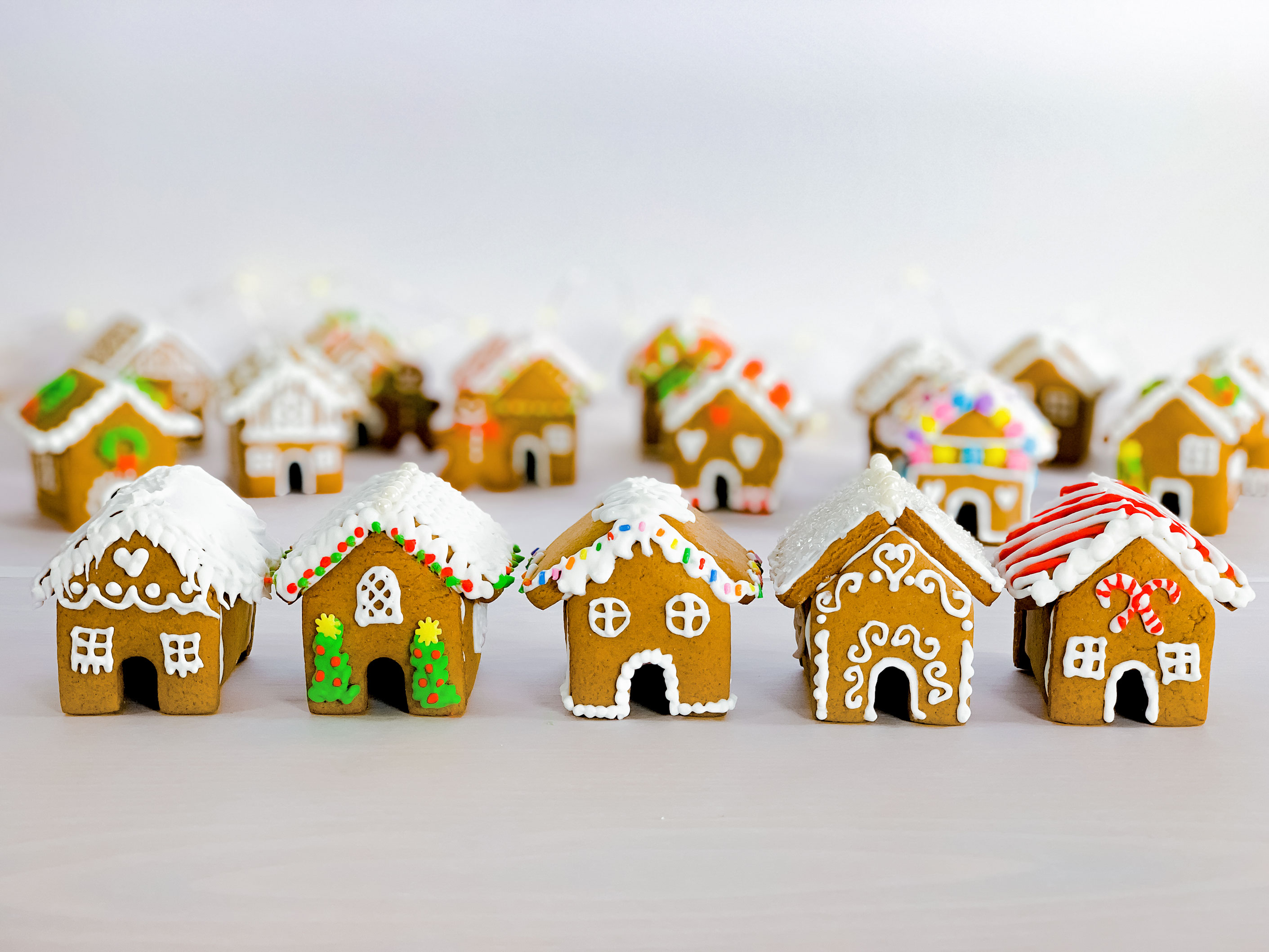 a group of mini gingerbread houses after they have been decorated