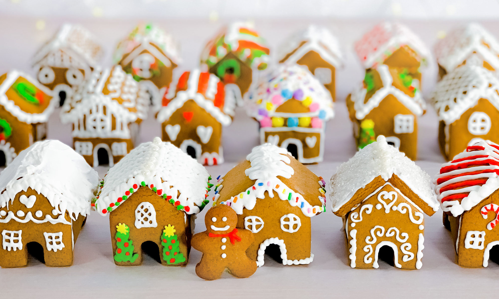 a group of mini gingerbread houses after they have been decorated