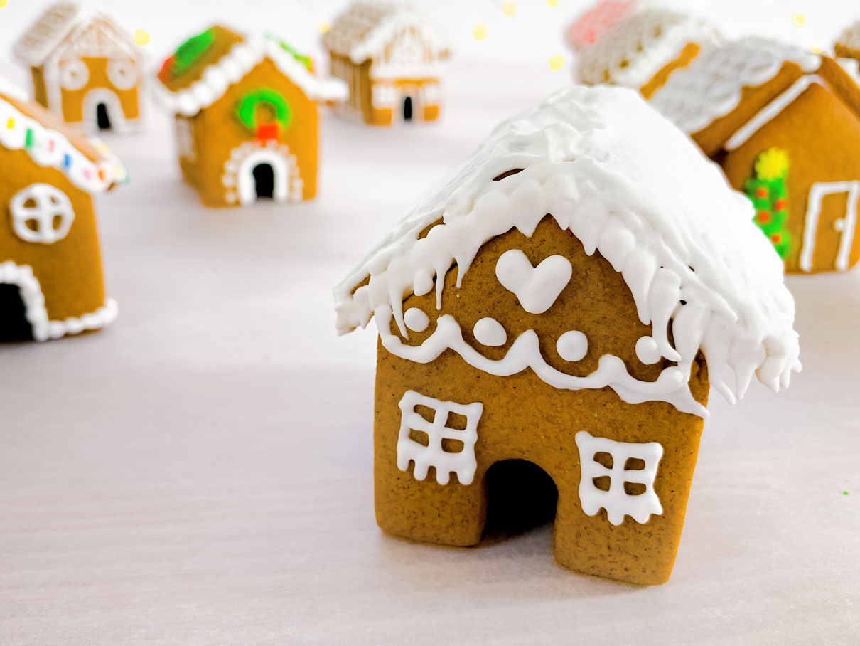 close up of a mini gingerbread house, with icicles on the roof and a heart above the door