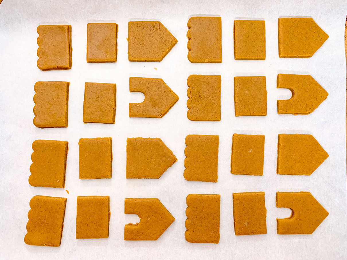 the gingerbread house pieces on a cookie sheet, ready to go in the oven