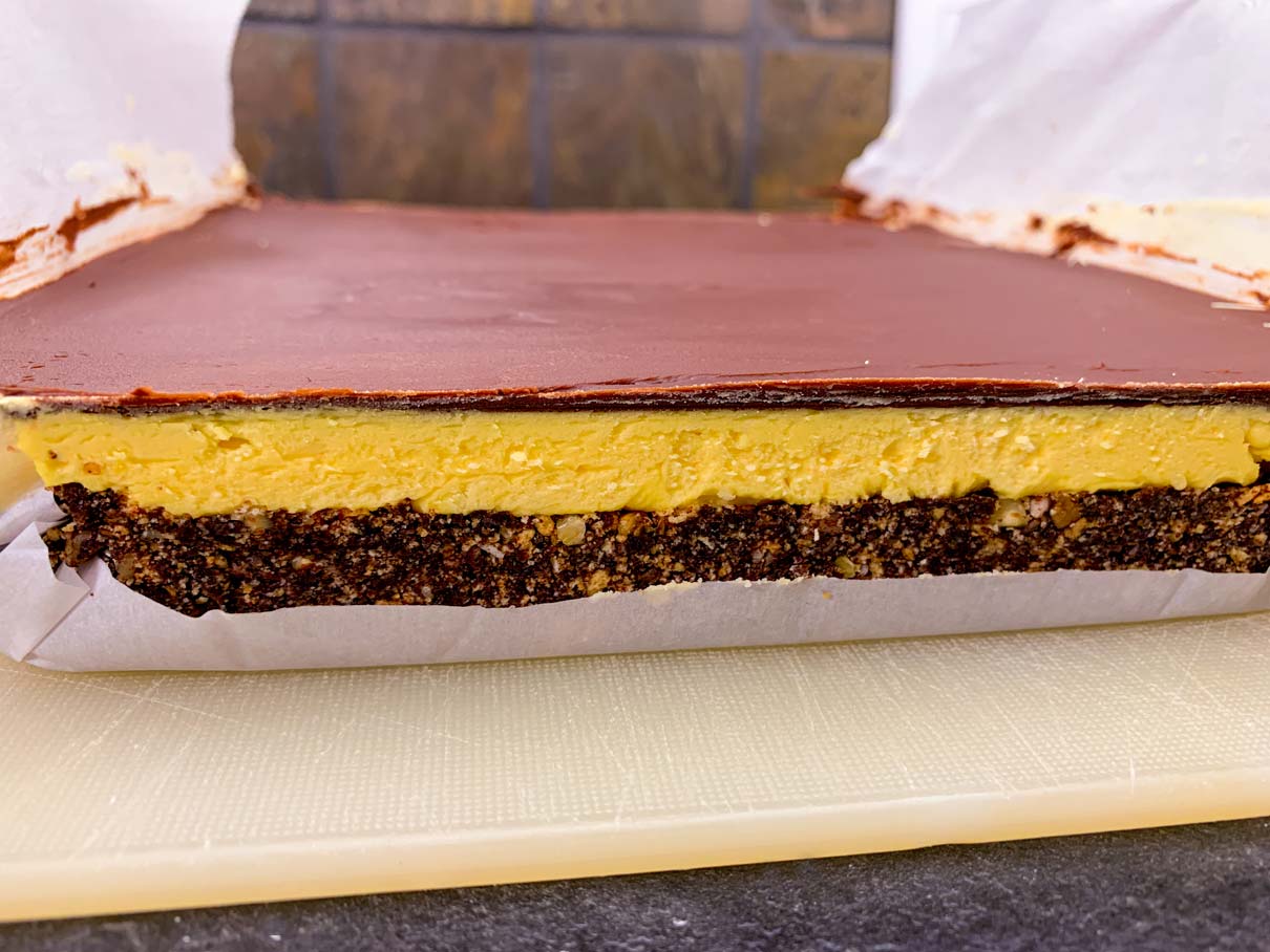 A side view of the Nanaimo bars, after the whole block has been lifted out from the pan