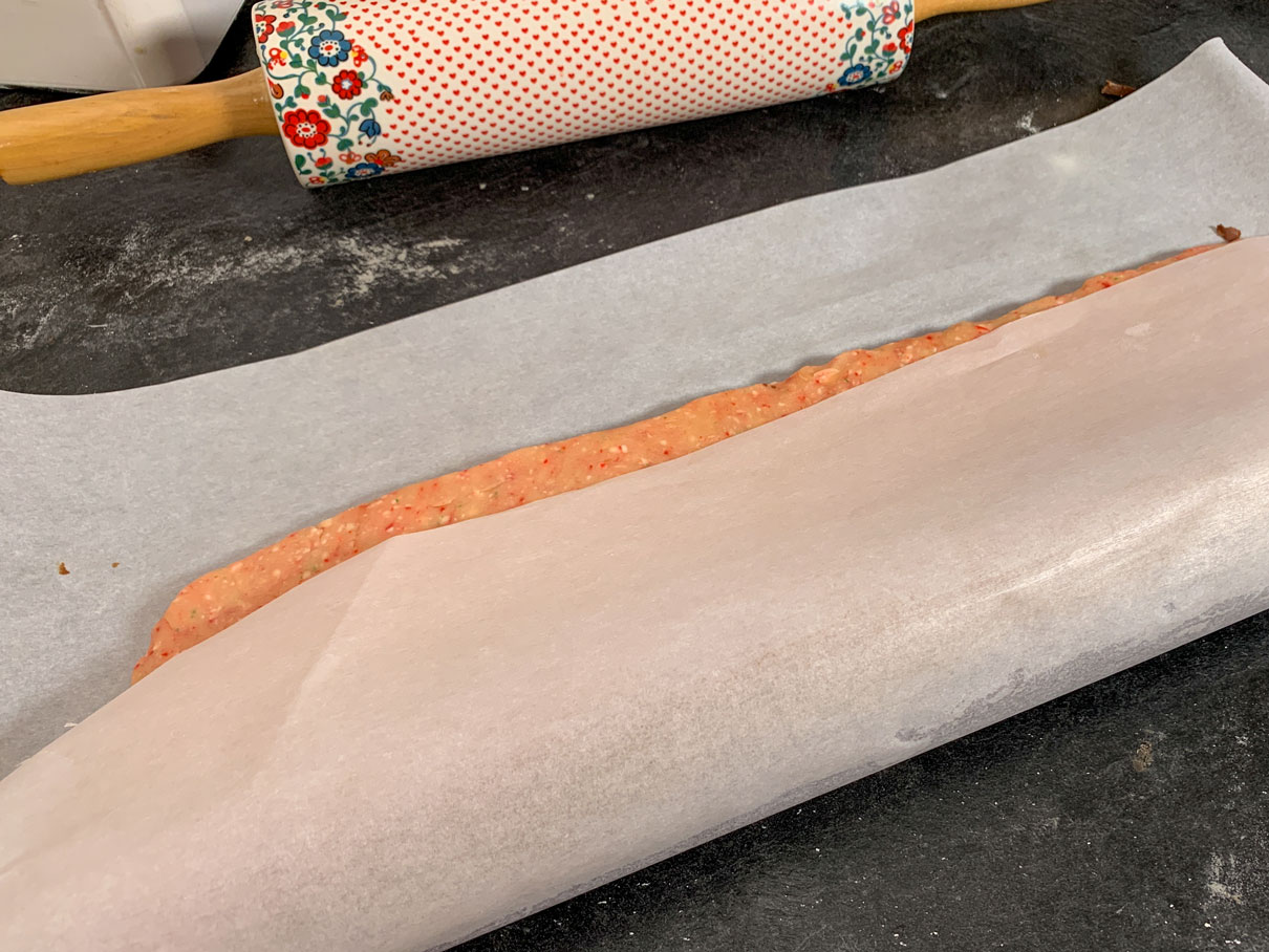 Rolling the dough in a piece of parchment to make a log
