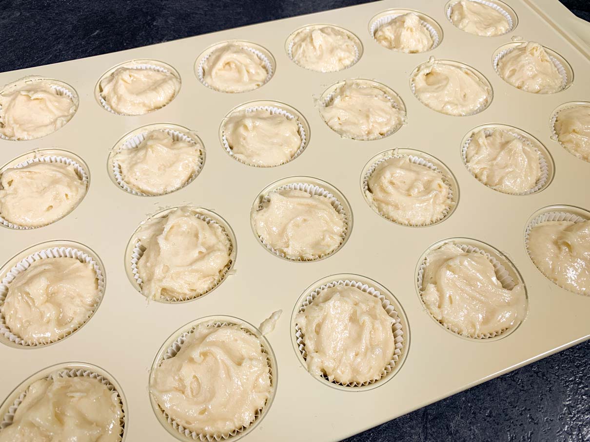 Mini cupcake pan with liners filled with batter