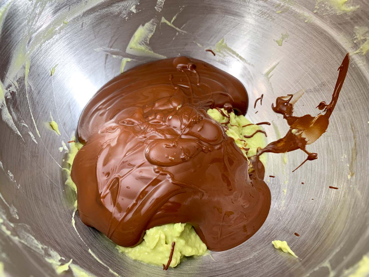 adding the melted chocolate and other ingredients to the mashed avocado