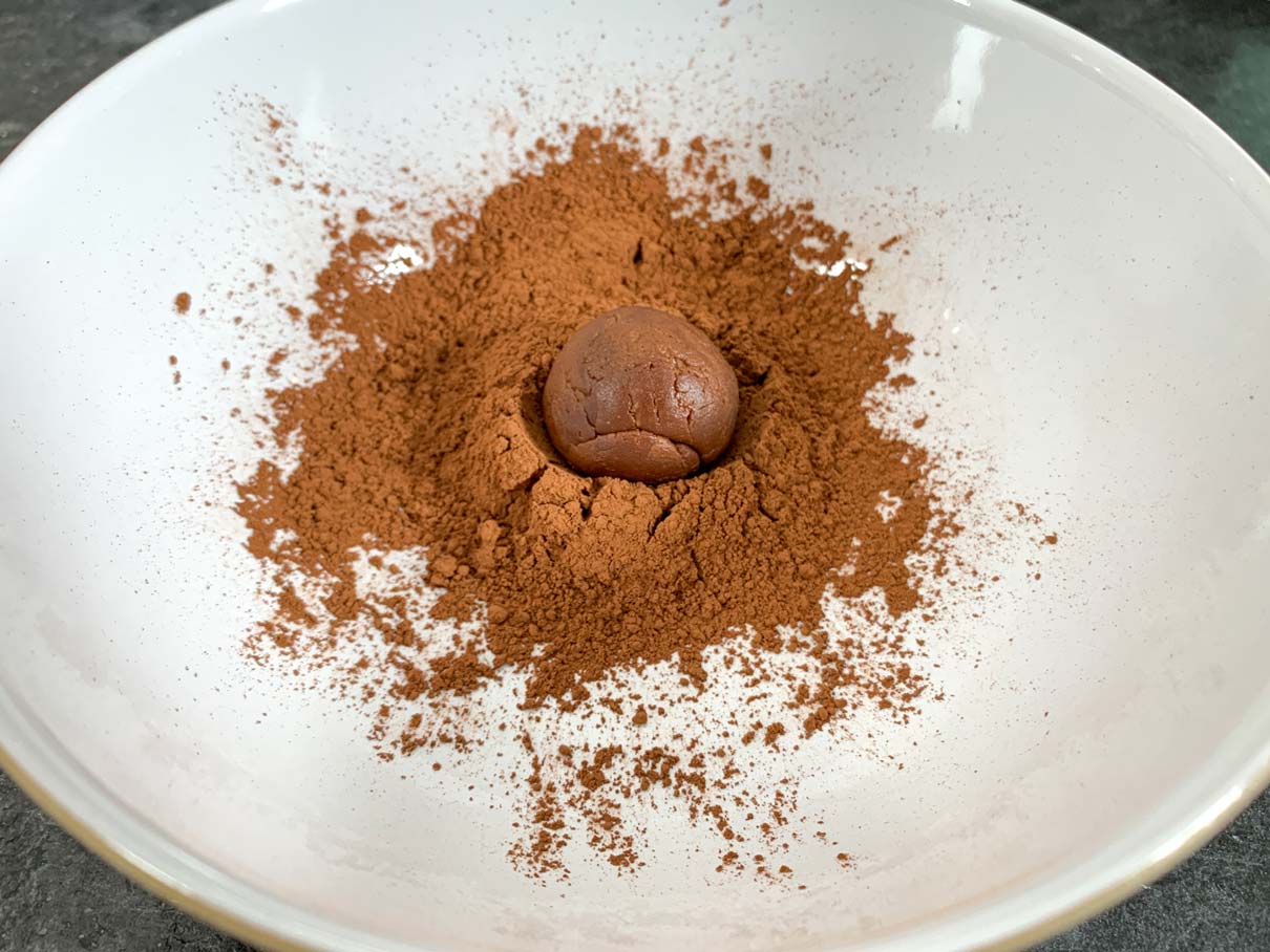 rolling a chocolate ball in cocoa powder