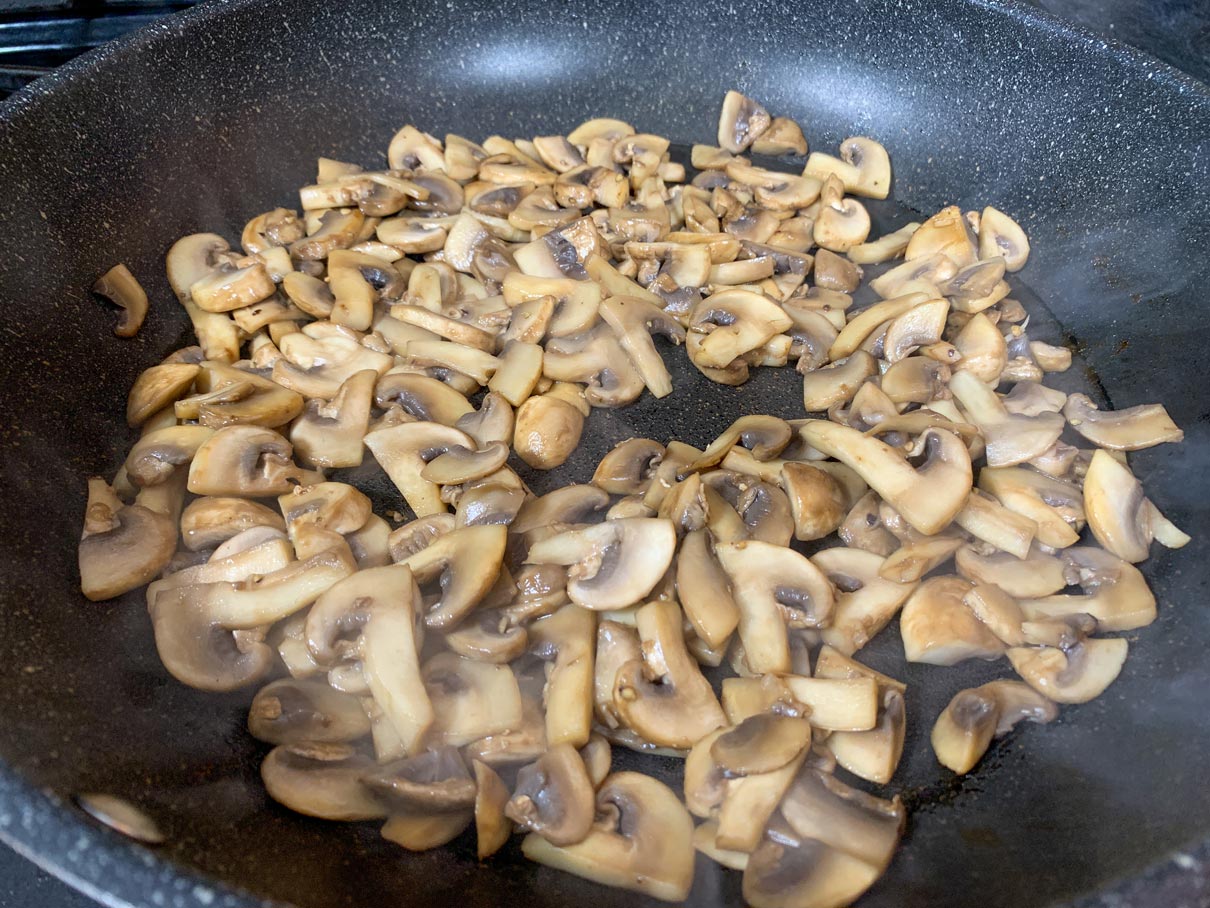 cooked sliced mushrooms in a frying pan