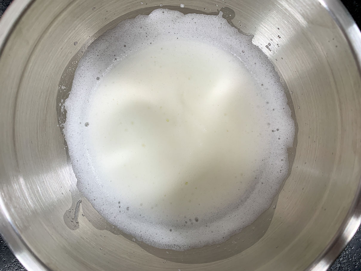 Foamy egg whites in a bowl