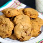 Close up of plate of cookies with glass of milk in the background