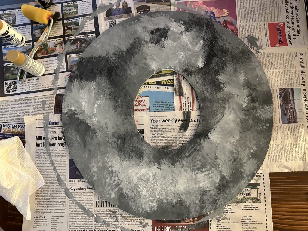 Foam core circle after painting it to look like the texture of clouds.