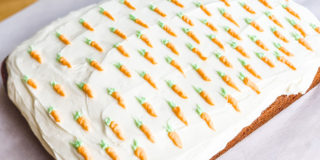 frosted carrot cake, with tiny carrots piped on top