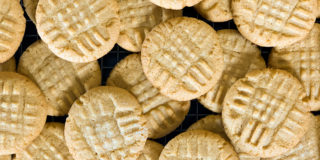 Peanut butter cookies stacked on a wire cooling rack