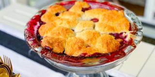 mixed berry cobbler, resting on a cake stand, ready for serving