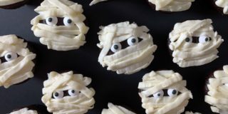 decorated mummy cupcakes on a black background