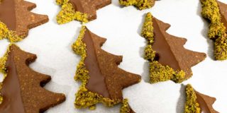 Tray of finished cookies, dipped in chocolate with pistachios crusted on the edges